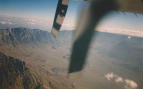 Overflight over the Mistal Bowl (20km wide), the second largest tectonic window in the Jebel Akhdar Mountains, North Oman: Permo-Triassic carbonates (cliffs) overlying Proterozoic metamorphic rocks.